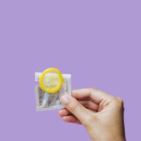 Mano che tiene preservativo